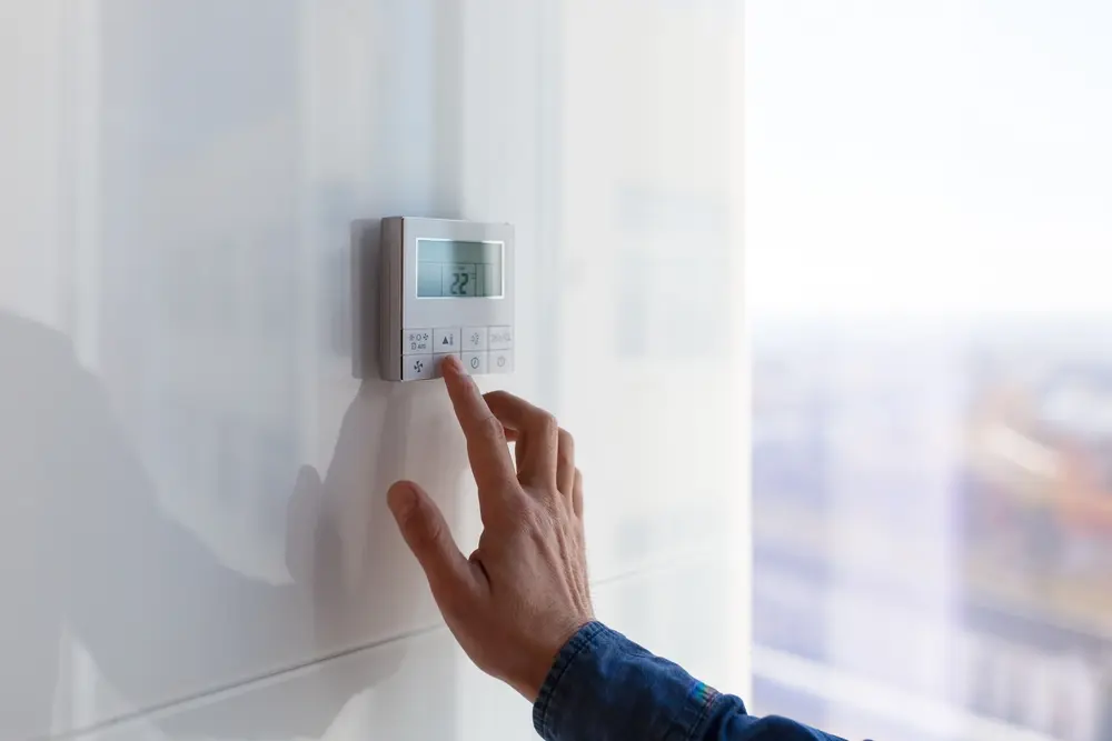 The air conditioning and heating control panel for the apartment is located on a white wall