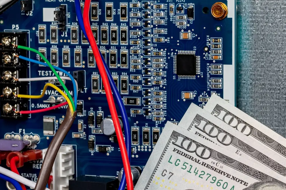 Furnace circuit control board and cash money. HVAC maintenance, repair, service and installation concept.